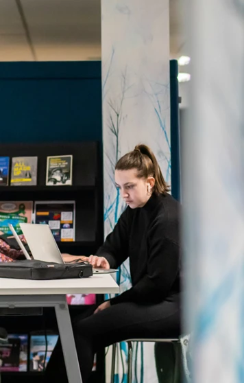 Student working on a laptop at a study desk in the Library and Flexible Learning Centre at Glasgow Kelvin College’s Easterhouse Campus, with bookshelves and resources in the background. Student working on a laptop at a study desk in the Library and Flexible Learning Centre at Glasgow Kelvin College’s Easterhouse Campus, with bookshelves and resources in the background.